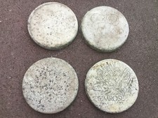 Four concrete stepping stones deplicting flowers. 