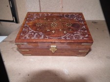 A WOODEN APOTHECARY BOX WITH BRASS INLAY ON TOP AND BRASS CORNERS
