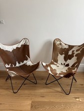 A pair of Brown And White Real Cow Hide Butterfly Back Occasional Pair Of Chairs