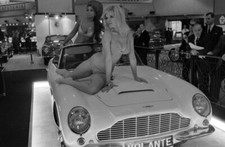 Models pose on an Aston Martin