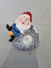 solar light garden gnome on a rock