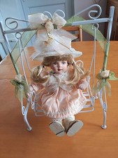 porcelain doll on a swing.