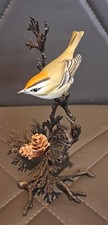 A Metal Sculpture Of  GOLDCREST WARBLER On A Branch With Cones
