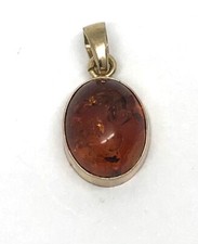 Small 9ct gold amber oval pendant, Birmingham hallmark, 10 x 8mm. Tiny defect.