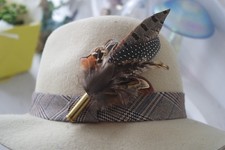 feather and bullet brooch, hat