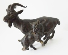 A vintage bronze sculpture of a nanny goat mother and her kid in playful pose.