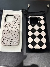 A Pair Of Burga iPhone 15 Pro Phone Cases In Beige And Black