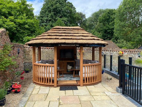 Oval wooden gazebo with thatch
