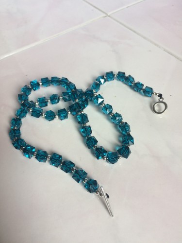 Teal coloured faceted cube - coloured,