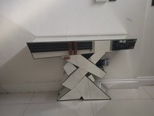 This glass console table is made of mirror glass, giving it a sleek and elegant 