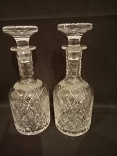 A MATCHING PAIR CUT CRYSTAL GLASS DECANTERS WITH STOPPERS