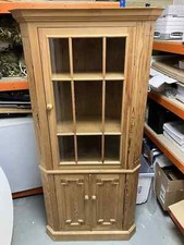 Tall corner cupboard made of pine with glass doors on top, wooden doors below