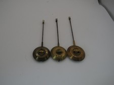 THREE VARIOUS VINTAGE CLOCK PENDELUMS