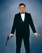 Robert Vaughn holding gun with
