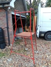 Henchman red platform step ladder with extending legs.
