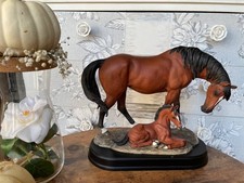horse statue , mother with her foal on wooden base
