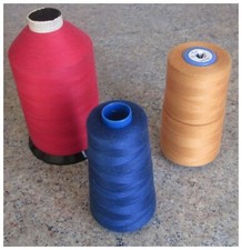 3 CONES OF OVERLOCK THREAD. Red, blue, orange.
