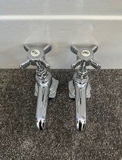 a pair of Victorian style chrome sink taps