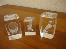 A SET OF 3 CLEAR GLASS 3D- LASER ETCHED PAPERWEIGHTS - COCKATOO DOLPHIN & GLOBE