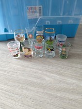 A collection of  8 shot glasses from around the globe