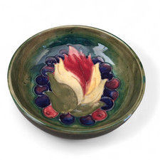 A SMALL MOORCROFT FOOTED SHALLOW DISH IN THE LEAF & BERRY PATTERN