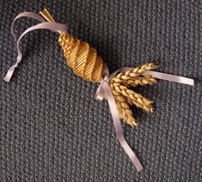 A small traditional handmade Corn Dolly. A straw gift with mauve satin ribbons