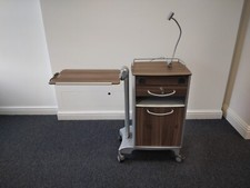 Dark wood cabinet with overbed table and lockable draw and light