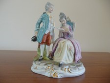 Leonardo collection seated lady and standing gentleman porcelain figurines.