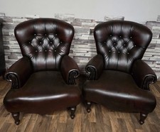 A pair of ox blood red leather chesterfield occasional chairs very unusual style
