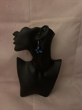 The blue and black fuse bead earrings are  displayed on a mannequin head.       