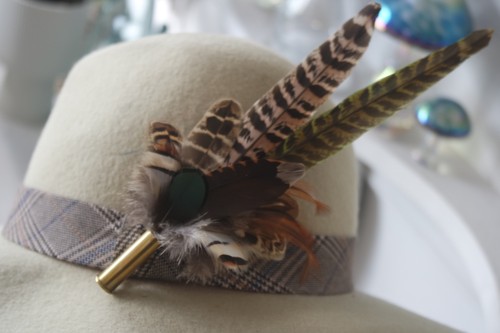 Feather and bullet brooch hat - and, brooch,