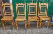 Chunky Indian oak style dining table with four chairs with wrought iron backs 
